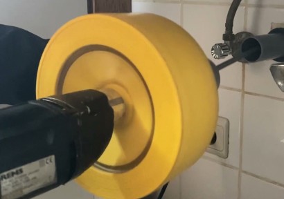 Plombier débouchant une canalisation sous un évier à Bruxelles